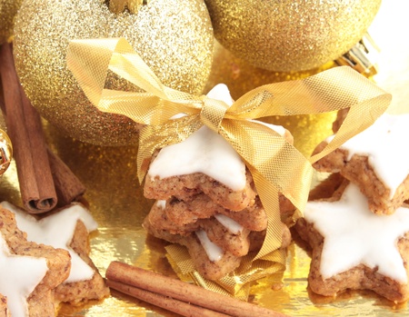 Star-shaped cinnamon cookies tied up to give as a gift. Decorated with gold Christmas decorations.の写真素材
