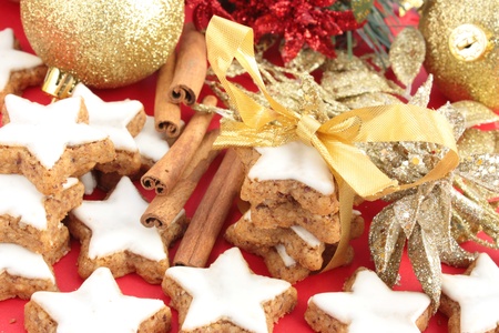 Star-shaped cinnamon cookies tied up to give as a gift. Decorated with gold, red and green Christmas decorations.の写真素材