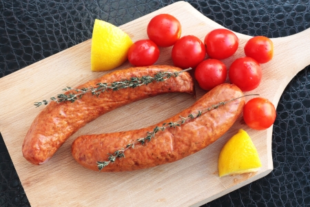 Sausages with cherry tomatoes, lemon and thymeの写真素材