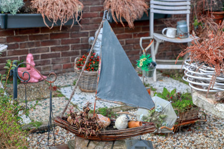 Garden decor for design. My home garden. A little sailboat (a souvenir from my vacation). Colorful vintage flower pots. Private zen garden concept. Boat modelの写真素材