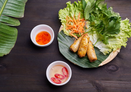 Fried spring rolls with sweet chili sauce and carrot on plate top viewの写真素材
