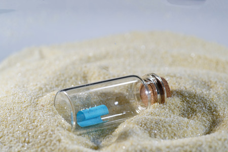 Bottle mail lying in the fine sandの写真素材