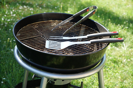 Cutlery for sausages barbecue with a charcoal barbecue in the gardenの写真素材