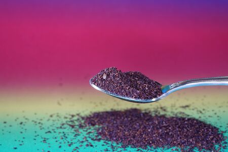 Sumac spice with macro lens photographed against colorful gradient in studioの写真素材