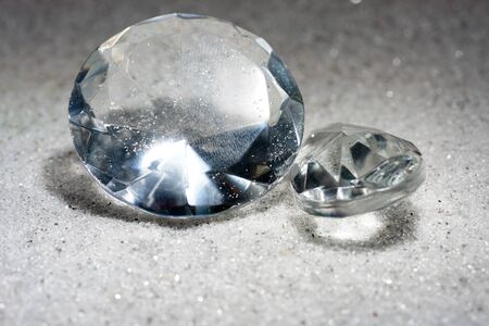 Artificial diamonds lying in the sand photographed in the studio with flash lightの写真素材