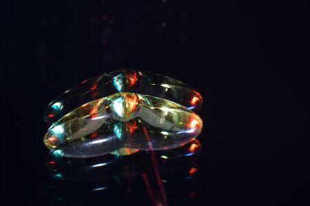 Colorful plastic heart photographed on mirror surface in studioの写真素材