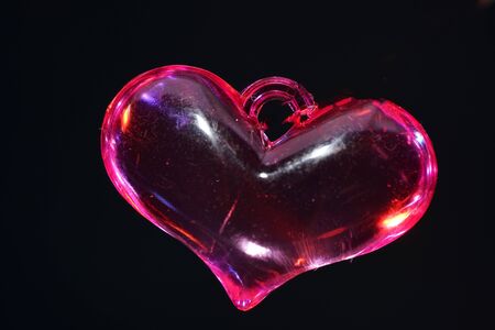 Colorful plastic heart photographed on mirror surface in studioの写真素材