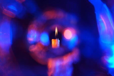 Candle with smoke and flame photographed in the studio with color foils before the flashesの写真素材