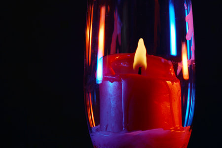 Candle with smoke and flame photographed in the studio with color foils before the flashesの写真素材