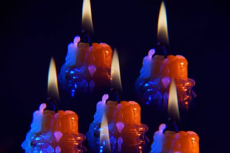 Candle with smoke and flame photographed in the studio with color foils before the flashesの写真素材