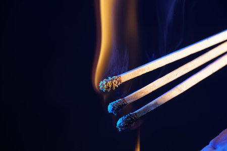 Lit matches and blown out in the studio photographed with colorful foils before the flashesの写真素材