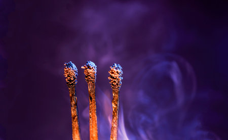 Lit matches and blown out in the studio photographed with colorful foils before the flashes