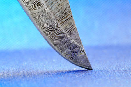 Hand-forged knife made of several layers of steel with an exclusive pattern photographed in the studioの写真素材