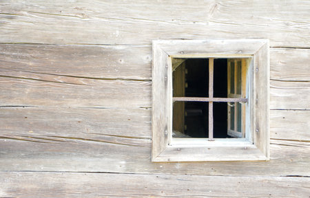Aged wooden window with glazing and partially weathered in rustic homesの写真素材