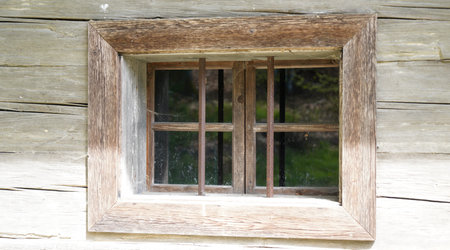 Wooden window with glazing and partially weathered in rustic homesの写真素材