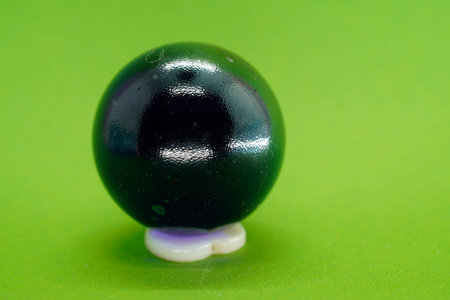 A close up shot of a marbles ball on a green background