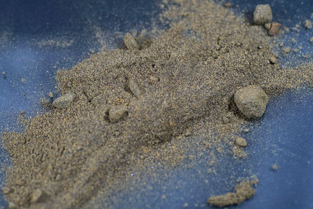pile of sand on the blue background, closeup of photo