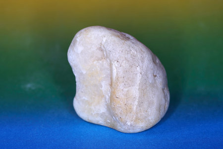 White stone on a green-yellow-blue background. Macro photography.