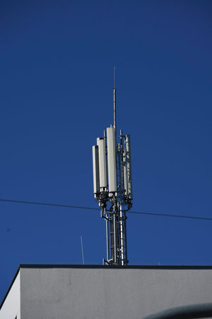 telecommunications tower on a building with blue sky in the background.