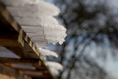 snow on the roof of a wooden house, close-up