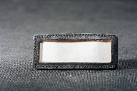 Black leather label on black fabric background. Shallow depth of field.の写真素材