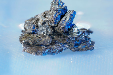 Close-up of a piece of coal on a blue background.の写真素材