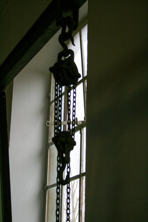 A window with iron lattice and a metal chain on it.