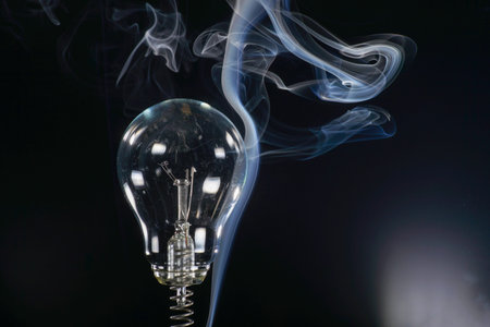 Incandescent lightbulb with smoke on black background, close upの写真素材