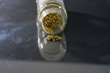 Marijuana buds in a glass jar on a black background close upの写真素材