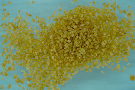 close up of a pile of bulgur groats on blue background