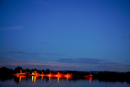 Night view of the lake with a reflection of the stars in the waterの写真素材
