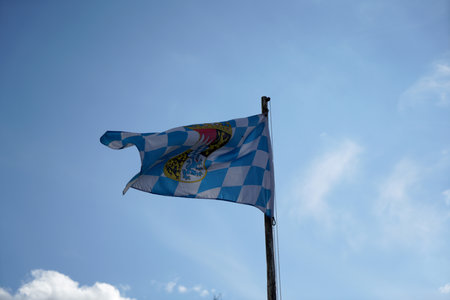 Bavarian flag waving in the wind on a blue sky backgroundの写真素材