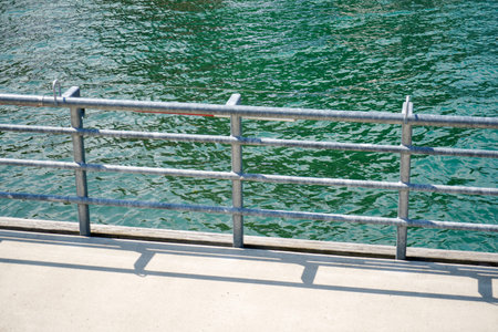 Detail of a pier with a metal railing in the sea.の写真素材