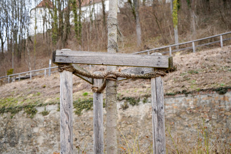 Wooden post with rope on a background of the old wall.の写真素材