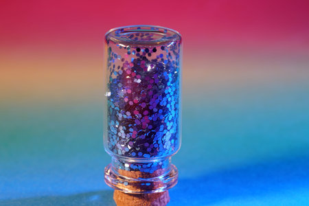 Nail polish in a glass on a multicolored background.の写真素材