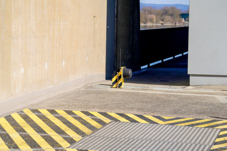 Entrance to the parking lot with yellow and black warning stripes.の写真素材