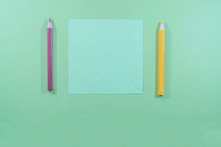 Blank sheet of paper and pencil on a green background with copy spaceの写真素材