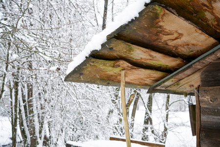 wooden gazebo covered with snow in the winter forestの写真素材