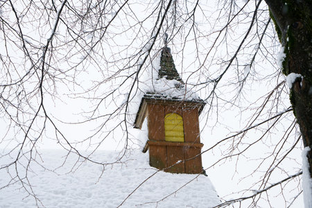 Wooden bell tower in the winter forest. Winter landscape with snowの写真素材
