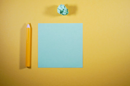 Colored pencils and paper on a yellow background