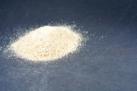Pile of flour on a black background. Selective focus.
