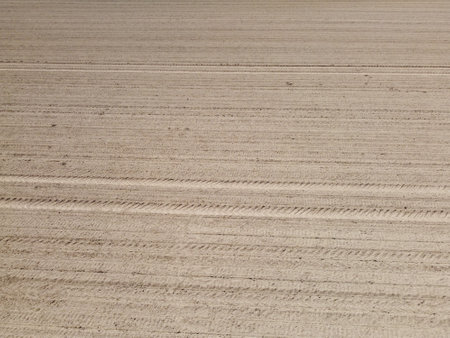Aerial view of a freshly ploughed field with tractor tracksの写真素材