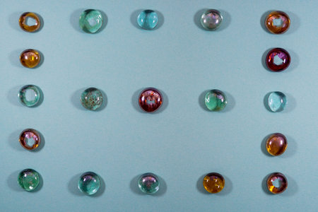 Colorful glass beads on blue background. Flat lay, top view.の写真素材