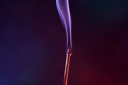Incense stick with smoke on a black background, close-upの写真素材
