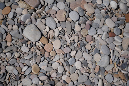 pebbles on sea beach washed round and flat