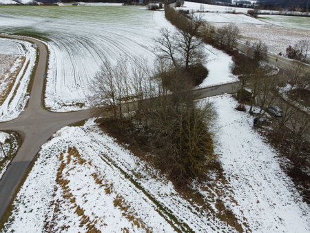 Drone shot of snowy agricultural snowy fields in Bavaria on a cloudy dayの写真素材