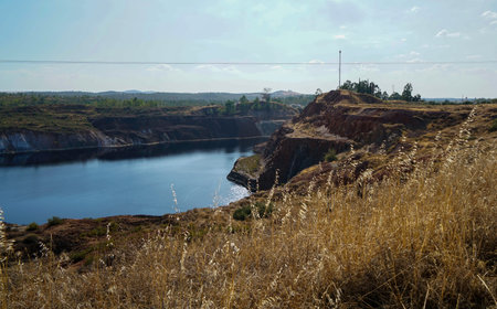 Abandoned quarry with blue lake in the middle of the field