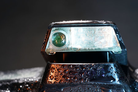 Close-up view of a vintage car headlight on black backgroundの写真素材