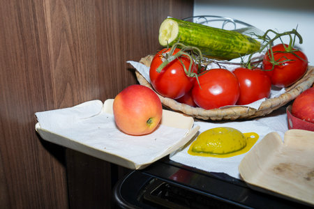 preparation of salad with tomatoes and cucumbers in the kitchenの写真素材