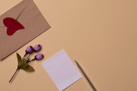 Greeting card for the day of compliments. spring flowers on a beige background and a red heart.